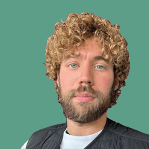 Portretfoto van Floris van Paridon, lachend met krullend haar en blauwe ogen, voor een effen groene achtergrond.