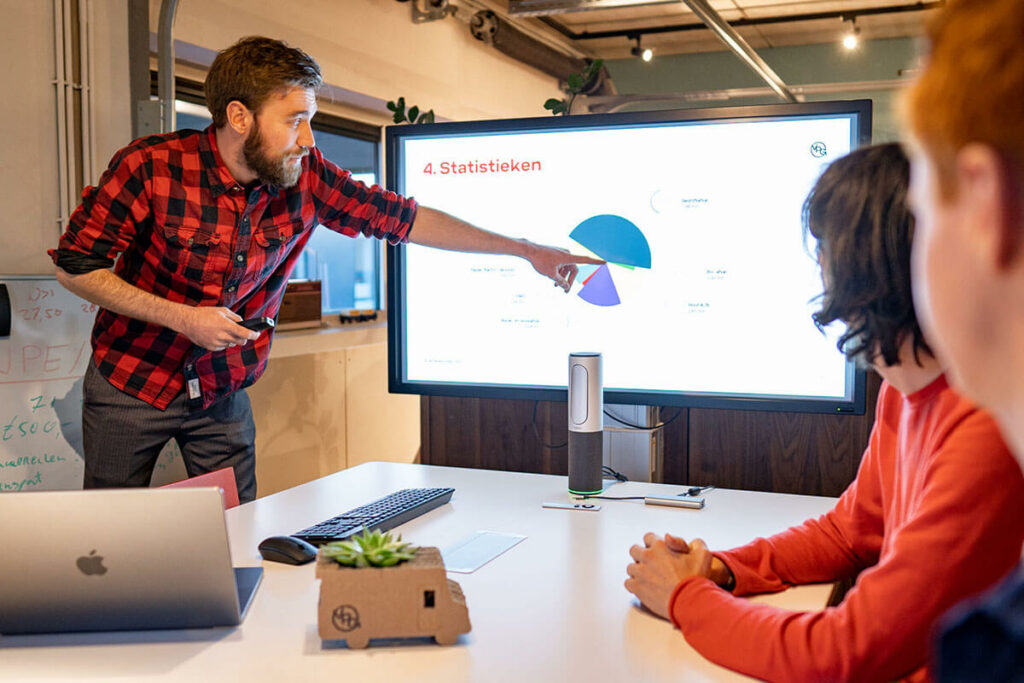 Medewerker What A Waste geeft een presentatie over afvalbeheer statistieken en werkwijze.